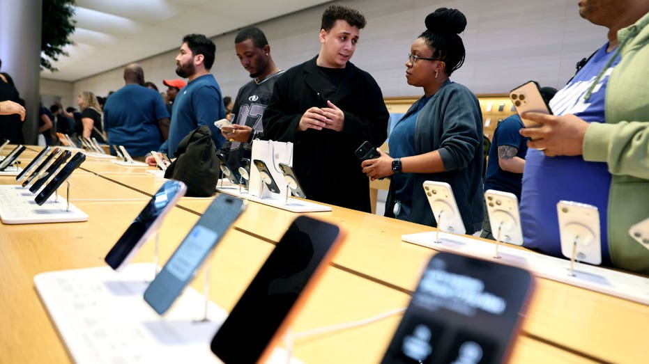 يتسوق الأشخاص لشراء أجهزة iPhone من Apple في أحد المتاجر.