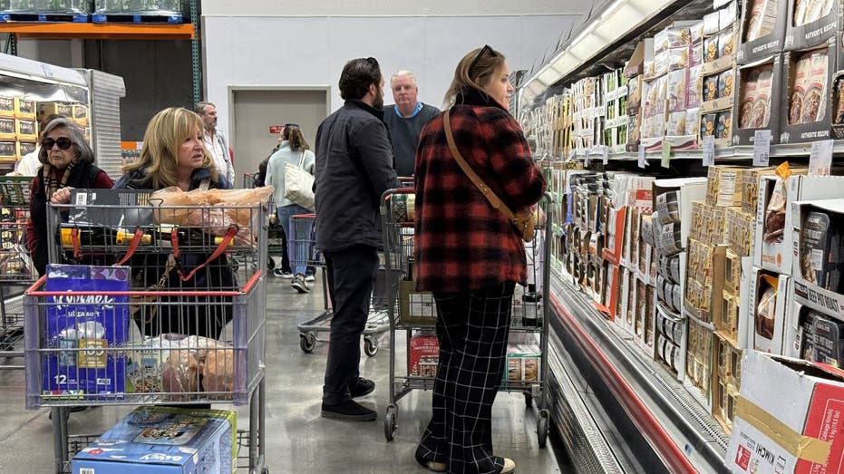 المتسوقون ينظرون إلى أسعار البقالة