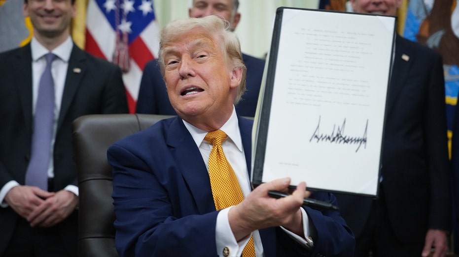 الرئيس الأمريكي دونالد ترامب يعرض أمرا تنفيذيا وقعه في المكتب البيضاوي بالبيت الأبيض